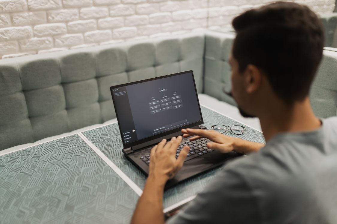 Person working on laptop with AI tools for side hustle income